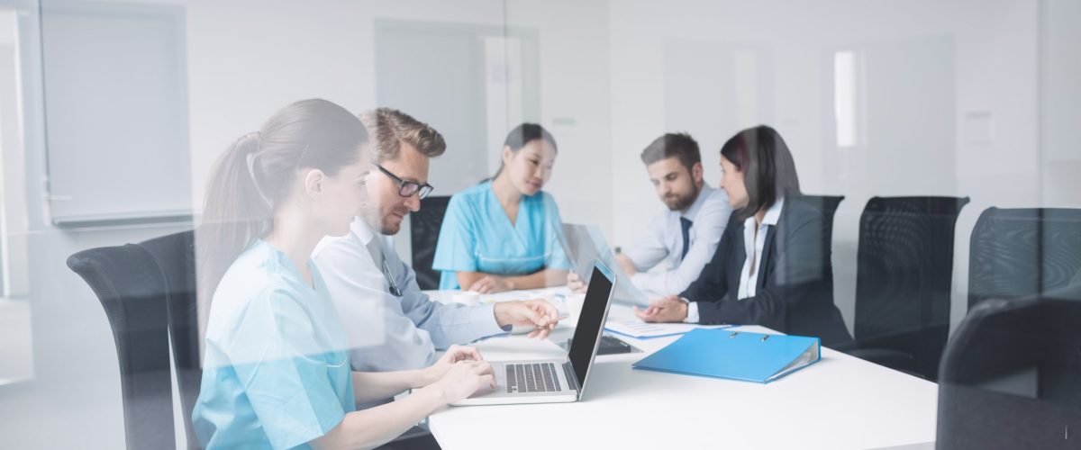 Doctors discussing over laptop in meeting at conference room